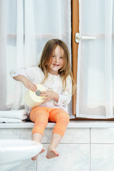 Cute little girl playing with toilet paper roll