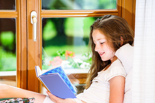 Cute teenage girl siiting on window siil
