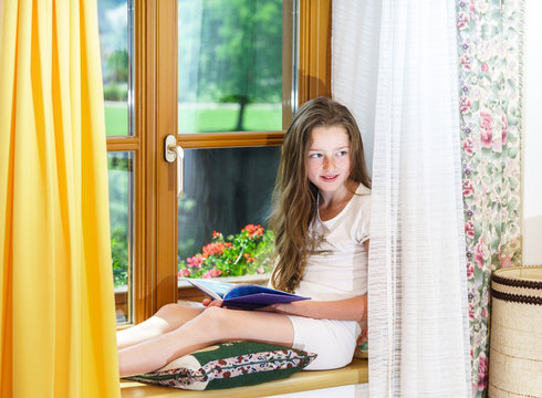 Cute teenage girl siiting on window siil