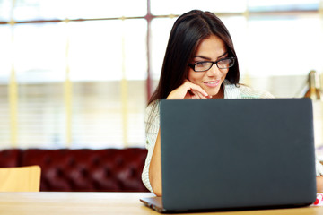 Happy businesswoman working on the laptop at office