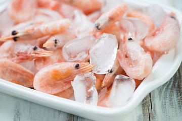 Close-up of frozen shrimps on ice cubes, horizontal shot