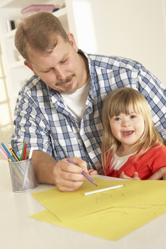 Father and Downs Syndrome daughter drawing