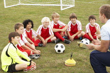 Junior football team training with coach