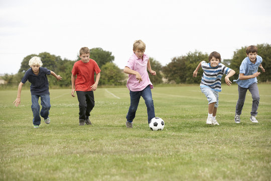 Boys Playing With Football In Park