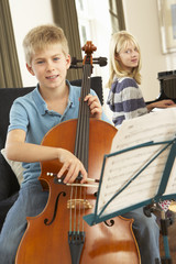 Boy and girl playing cello and piano at home © Monkey Business