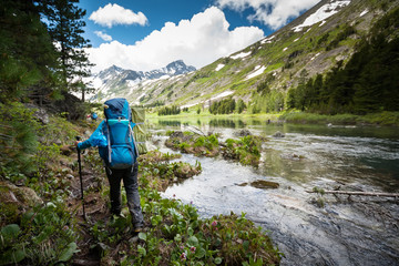 Hiker is walking by mountain lake in Altai mountains, Russia