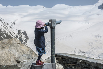 Mädchen sieht durch Fernrohr auf Gornergrat , ob Zermatt, Wallis, Schweiz