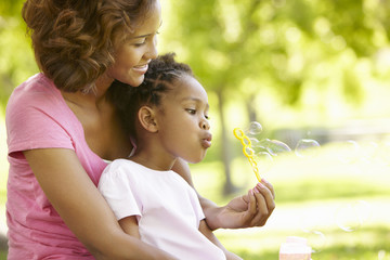 Fototapeta premium Mother and daughter blowing bubbles