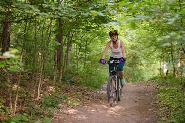 Fototapeta premium Woman is cycling in spring forest