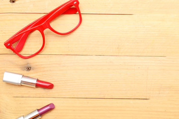 Makeup and glasses on wood