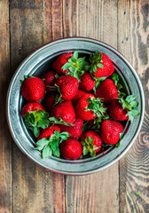 Strawberries in a bowl on wooden background