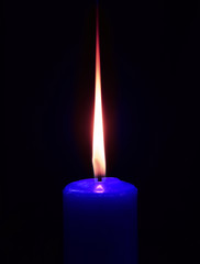 Closeup of burning candle on black background