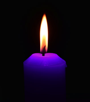 Closeup of burning candle on black background