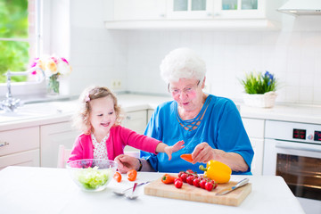 Grandmother and little girl making salad