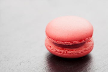 Single pink macaroon on rough background