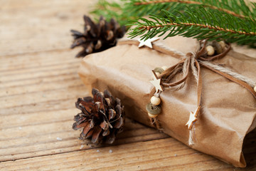 Christmas packed present with x-mas tree branches and pine cones