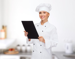 smiling female chef with black blank paper