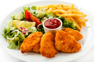 Fried chicken nuggets, French fries and vegetables