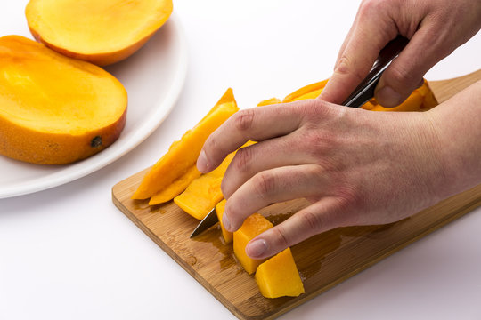 Ausgel&ouml;stes Fruchtfleisch der Mango in W&uuml;rfel schneiden