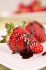 strawberry in chocolate on white plate