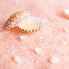 Obraz na płótnie Canvas spa concept with seashells and pearl on delicate pink terry text