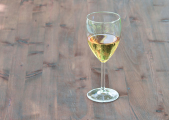 glass of white wine on board old natural wood