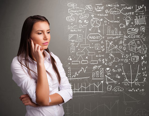 Fototapeta premium Pretty woman looking at stock market graphs and symbols