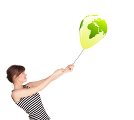 Happy lady holding a green globe balloon