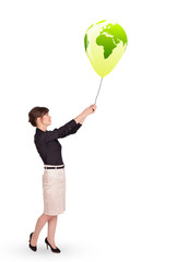 Happy lady holding a green globe balloon