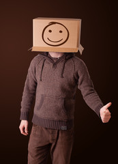Young man gesturing with a cardboard box on his head with smiley