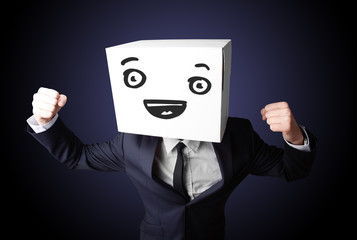 Businessman gesturing with a cardboard box on his head with smil