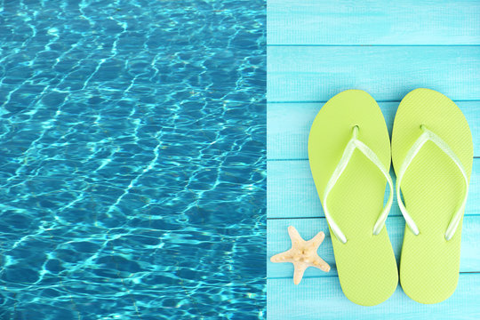 Colored flip flops on wooden platform beside sea