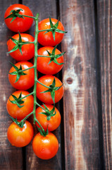 Ripe fresh cherry tomatoes on wooden background