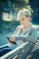 beautiful young blonde short hair hipster woman using tablet