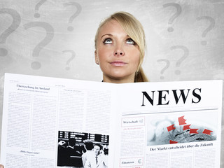 Woman reading newspaper is very anxious
