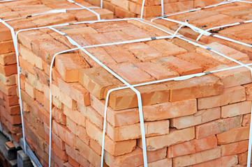 Stack of orange clay brick on construction site