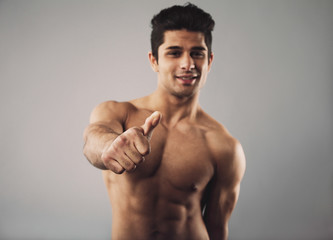 Fototapeta premium Happy bodybuilder showing thumbs up sign