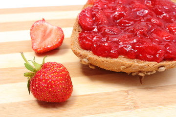 Wholemeal roll with strawberry jam and fresh fruits