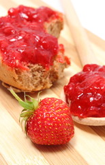 Fresh fruits and strawberry jam on wooden cutting board