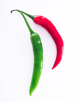 Rote und gr&uuml;ne Peperoni vor wei&szlig;em Hintergrund