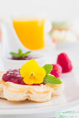 Crispy toast in flower shape with butter and raspberry jam 