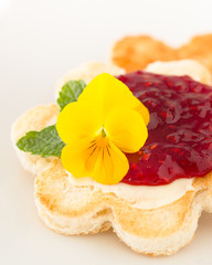 Obraz na płótnie Canvas Crispy toast in flower shape with butter and raspberry jam. 