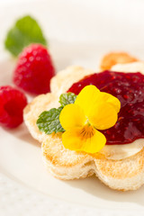 Crispy toast in flower shape with butter and raspberry jam. 