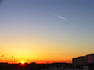 Fototapeta na wymiar Sunset over the city. The sun sinks behind the buildings.