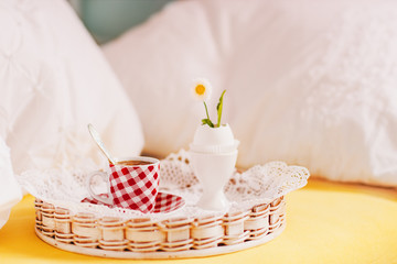 Breakfast in bed: hot espresso and little flower in eggshell. 