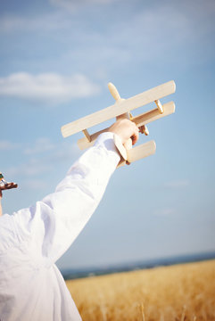 Little boy playing in farmland with a toy airplane