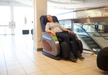 Woman in the massage chair in the trade centre