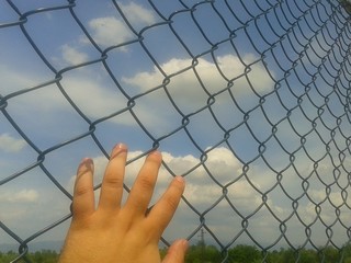 Hand on metal wire close up