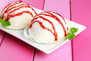 Delicious coconut cakes on plate on table close-up