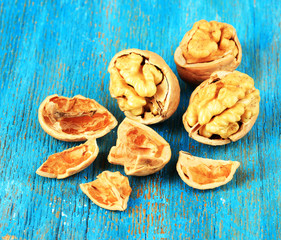 Broken walnuts on wooden table close-up